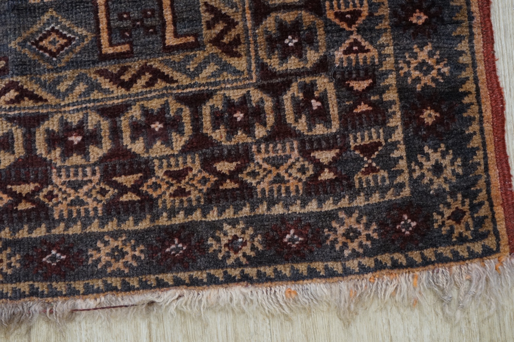 A small brown and red ground rug, 86cm wide
